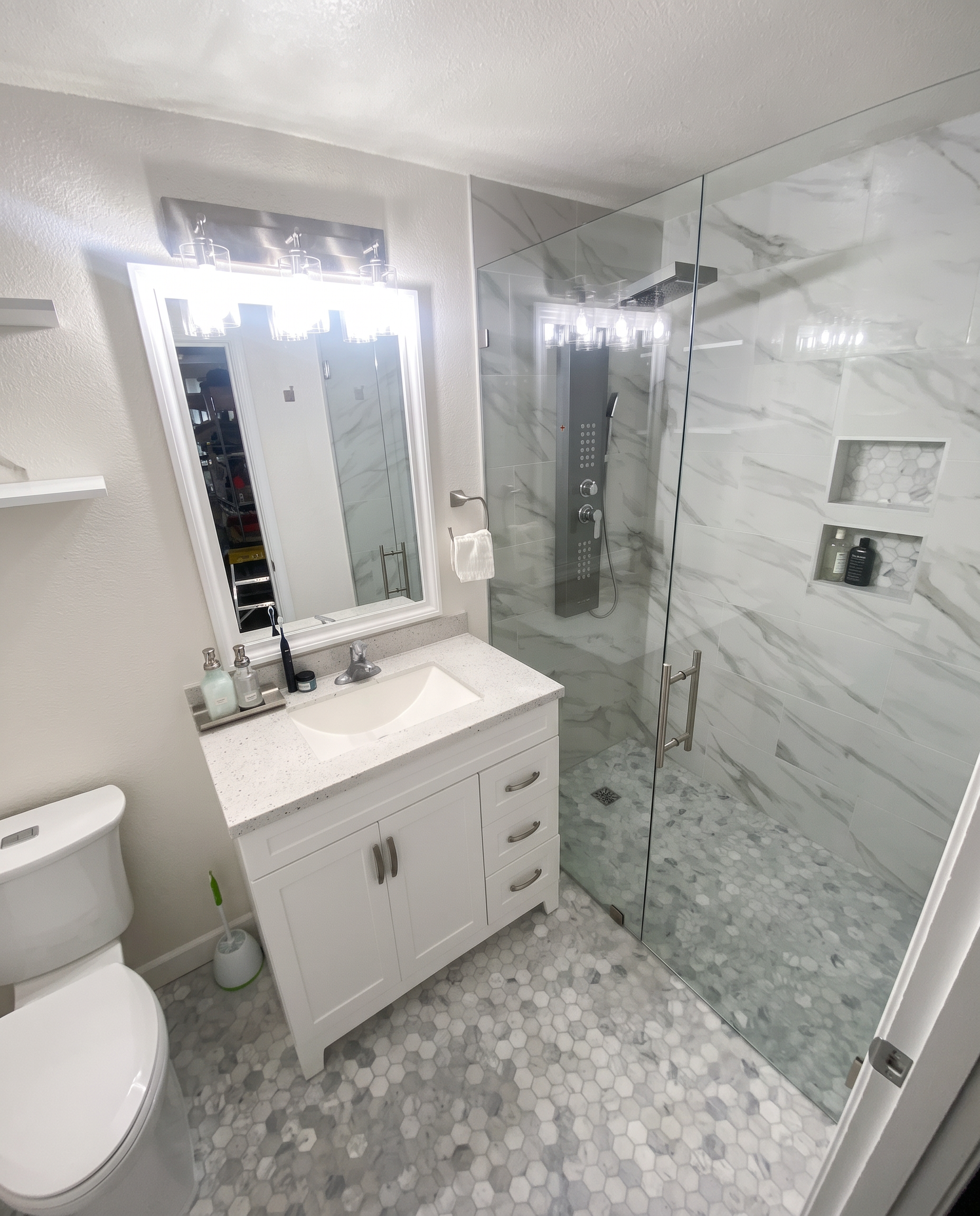 White vanity, hexagon floor tile and glass shower from supplied project photography